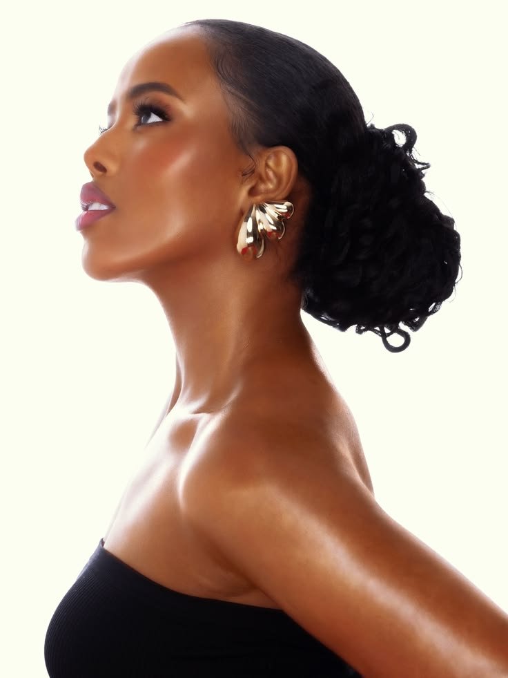 Mulher de perfil com brincos dourados em pétala